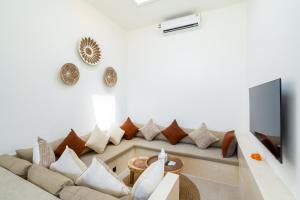 a living room with a couch and a tv at Villa Flambard in Canggu