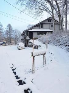 a yard covered in snow with a house at Yamadasan Ski Lodge - Madarao in Madarao Kogen
