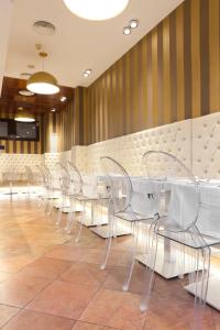 a row of white tables and chairs in a restaurant at Plaça De La Font in Tarragona