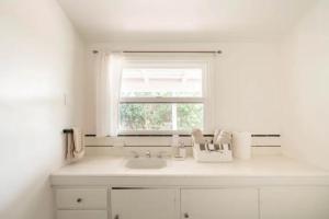 a white kitchen with a sink and a window at 30 PCT OFF! Malibu Villa, Ocean View, Beach, Hiking in Malibu +68 photos