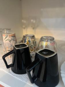 zwei schwarze Kaffeetöpfe auf der Theke in der Unterkunft Van Gogh residence Apartamento no Veneza in Ipatinga + 7 Fotos