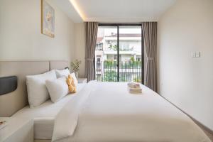 a large white bed in a room with a window at The Royal Vista - Phu My Hung in Ho Chi Minh City