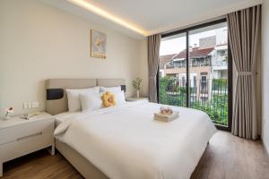 a bedroom with a large white bed and a large window at The Royal Vista - Phu My Hung in Ho Chi Minh City