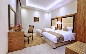 a hotel room with two beds and a chair at Luxury villas for rent in Jeddah +26 photos