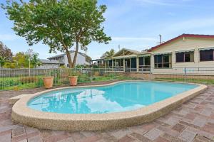 a swimming pool in front of a house at Waterfront Pet Friendly Abode Toukley NSW in Toukley