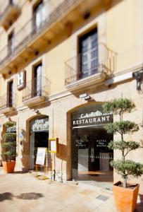 a restaurant sign on the side of a building at Plaça De La Font in Tarragona