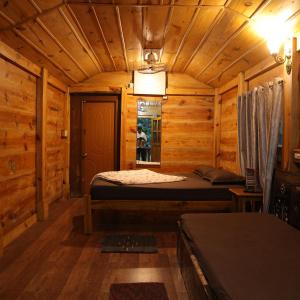 a bedroom with a bed in a wooden cabin at Farmers Son CampingGround in Sakleshpur +25 photos