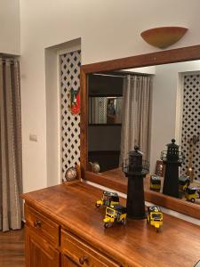 a mirror with two toy trucks on top of a dresser at Appartement T4 Standing Diégo-Suarez in Antsiranana