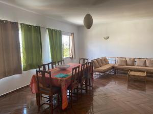 a dining room with a table and chairs and a couch at Appartement T4 Standing Diégo-Suarez in Antsiranana