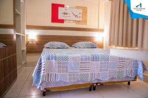 a bedroom with a bed with blue and white sheets at CAFÉ e ALMOÇO no LACQUA DIROMA Caldas Novas in Caldas Novas +27 photos