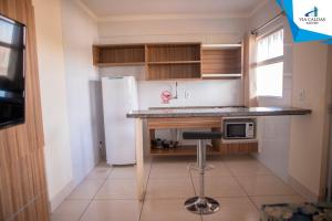 a kitchen with a counter and a refrigerator at CAFÉ e ALMOÇO no LACQUA DIROMA Caldas Novas in Caldas Novas