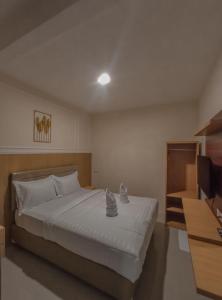 a bedroom with a large bed with white sheets at NiEr Guesthouse Zwei in Lumajang +5 photos