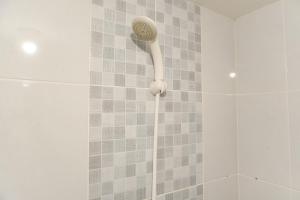 a shower with a shower head in a bathroom at Modern Look 2BR Tokyo Riverside PIK 2 Apartment By Travelio in Rawalembang +15 photos