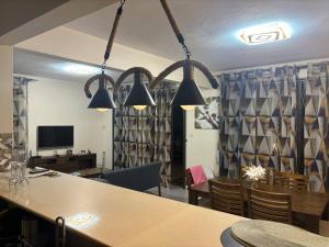 a dining room with a table and chairs and lights at Évasion Tropicale à 5 min des Plages in Albion