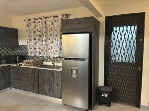 a kitchen with a stainless steel refrigerator next to a window at Évasion Tropicale à 5 min des Plages in Albion