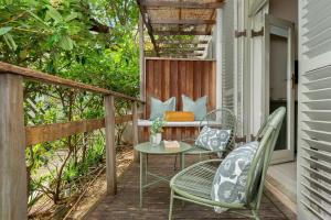 un patio avec une table et des chaises sur un porche dans l'établissement Neighbourgood Romney, au Cap