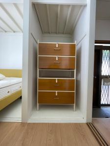un armadio con cassetti e un letto in una stanza di 一棟貸し宿ゲストハウスサンク a Masuda