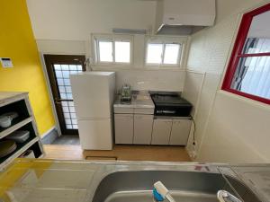 una cucina con frigorifero bianco in una camera di 一棟貸し宿ゲストハウスサンク a Masuda