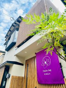 a purple sign on the side of a building at Mulan Stay 嵯峨嵐山 in Shimo saga