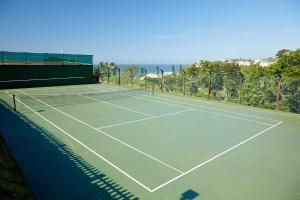a tennis court with the ocean in the background at Chakas Rock Chalet 39 in Ballito