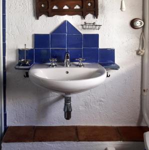 un fregadero blanco con azulejos azules en la pared en La Carrihuela, en Algodonales
