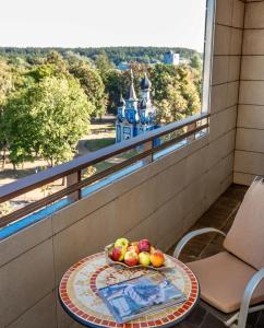 a bowl of fruit on a table on a balcony at DRUSKININKŲ PANORAMA Apartamentai in Druskininkai