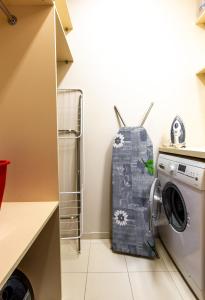 a washer and dryer in a small kitchen at DRUSKININKŲ PANORAMA Apartamentai in Druskininkai