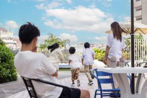 a group of people walking on a patio at Tokyu Stay Okinawa Naha in Naha