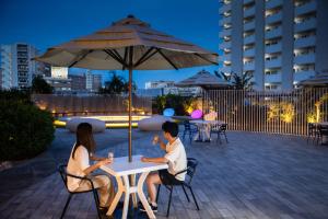 two people sitting at a table under an umbrella at Tokyu Stay Okinawa Naha in Naha +247 photos