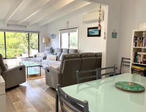 a living room with a couch and a table at SHELLHARBOUR BEACH COTTAGE - Stroll to Beach flags - Back gate straight to Beach, Front gate walk to new Marina in Shellharbour
