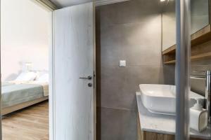 a bathroom with a sink and a bed at Κοράλι, μεζονέτα στην παραλία Λίμνης in Limni +71 photos