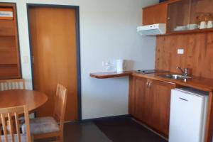 a small kitchen with a table and a refrigerator at G & G's Birds Eye View in Raglan