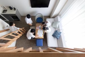 a group of people sitting at a table in a living room at Tokyu Stay Okinawa Naha in Naha