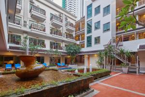 a courtyard with a large vase in front of a building at The Agate Pattaya Boutique Resort in Pattaya South