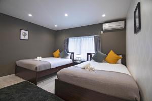 um quarto com duas camas e uma janela em 旅タイム・時光　鶴橋駅 em Osaka