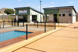 a swimming pool in front of a building at PrimVilla Apartment in Gaborone
