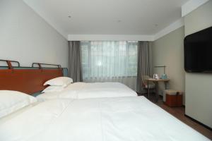 Uma cama ou camas num quarto em Echarm Hotel Qingyuan Qingcheng Station Municipal Government Shop