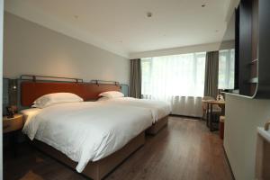 Uma cama ou camas num quarto em Echarm Hotel Qingyuan Qingcheng Station Municipal Government Shop