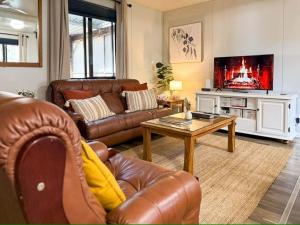 a living room with a leather couch and a table at The Hide, Bouvard in Dawesville