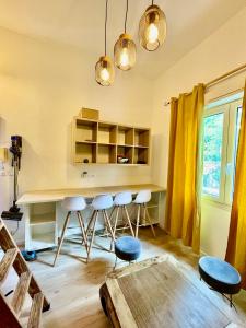 a kitchen with a table and stools in a room at proche kedge et universitée appartement cosy avec parking ,cuisine équipée ,sdb et jardin in Talence +21 photos