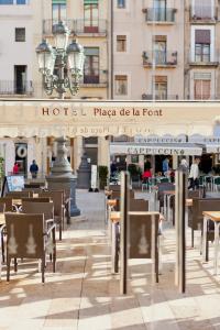 a dining area with tables, chairs and umbrellas at Plaça De La Font in Tarragona