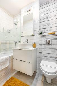 a white bathroom with a sink and a toilet at Perfect, relaxing and cozy apartment in Timişoara