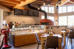 a restaurant with a bakery with tables and a counter at Saalbach Suites by ALPS RESORTS in Saalbach-Hinterglemm