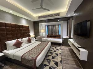 a hotel room with two beds and a flat screen tv at Hotel Sand Heaven in Port Blair