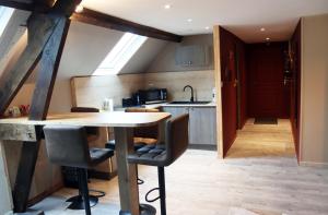 a kitchen with a table and chairs in a room at Logement Cosy type Loft près de Saint Quentin in Marcy +15 photos