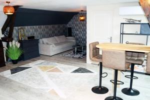 a living room with a table and a couch at Logement Cosy type Loft près de Saint Quentin in Marcy