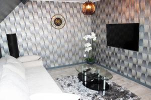 a living room with a white couch and a table at Logement Cosy type Loft près de Saint Quentin in Marcy