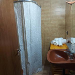 ein Badezimmer mit Waschbecken und Dusche mit Handtüchern in der Unterkunft Microcentro de la Docta in Cordoba + 6 Fotos