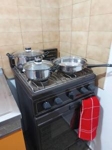 zwei Töpfe auf einem Herd in einer Küche in der Unterkunft Microcentro de la Docta in Cordoba