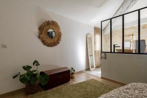 a bedroom with a mirror on the wall at Charmante maison en Arles : La Roquette in Arles
